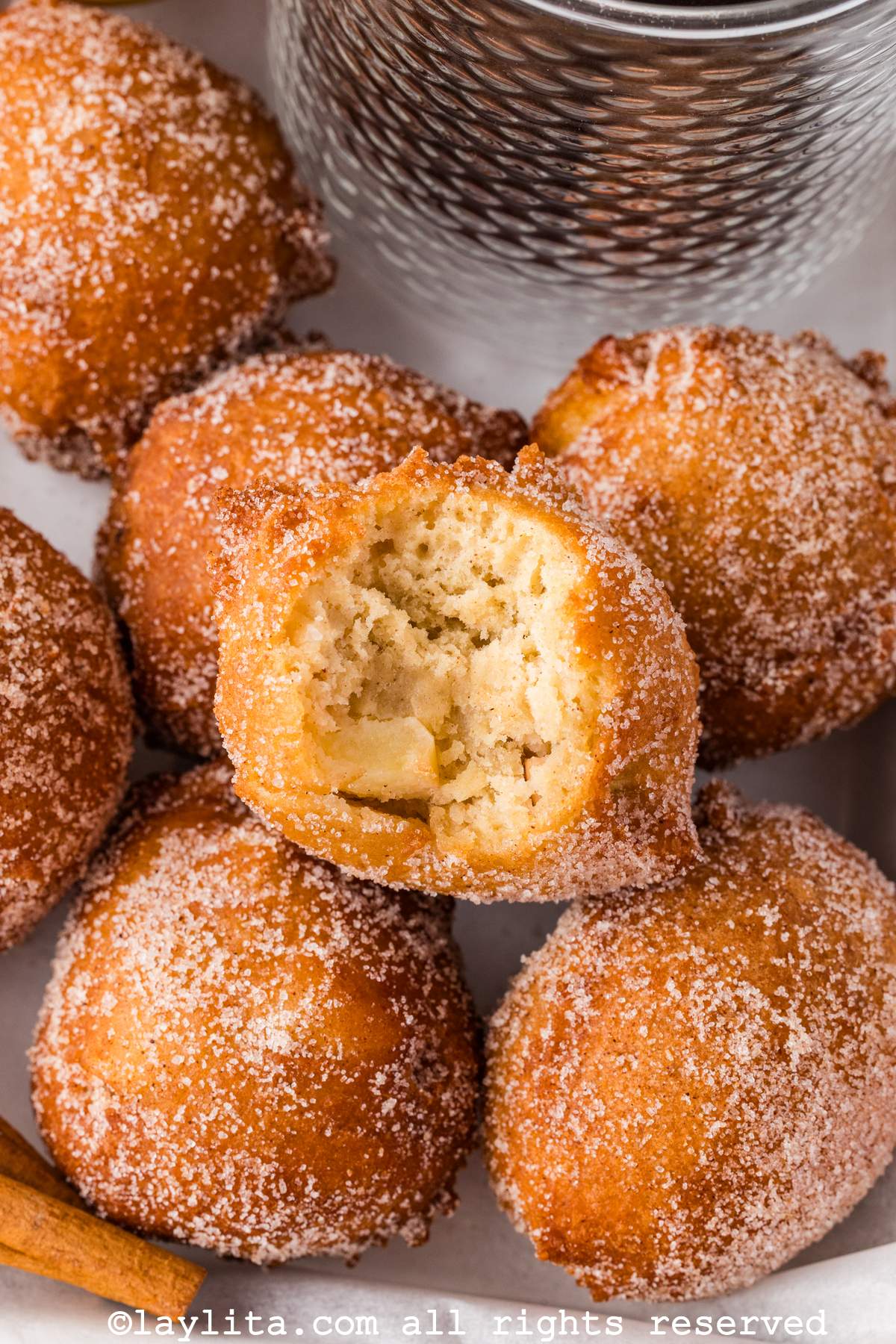 Close up of apple buñuelos with one of them missing a bite
