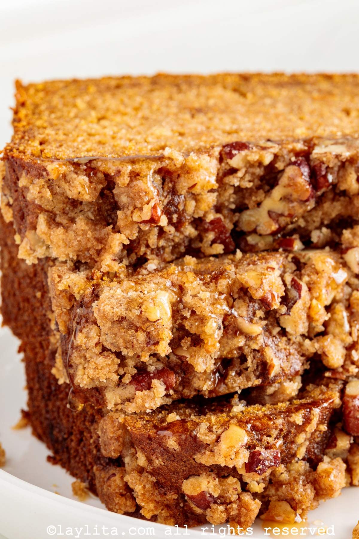 Closeup view of a the pecan streusel topping on several slices of sweet potato loaf