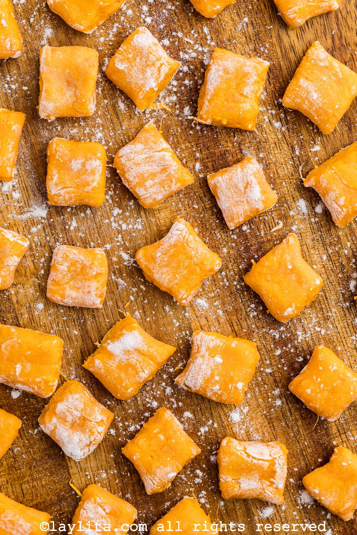 Closeup of uncooked freshly made sweet potato gnocchi on a wood board