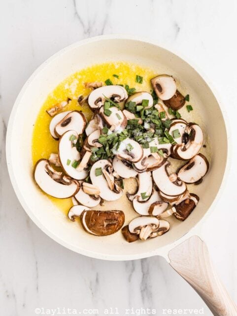 Mushrooms and sage in a skillet with melted butter
