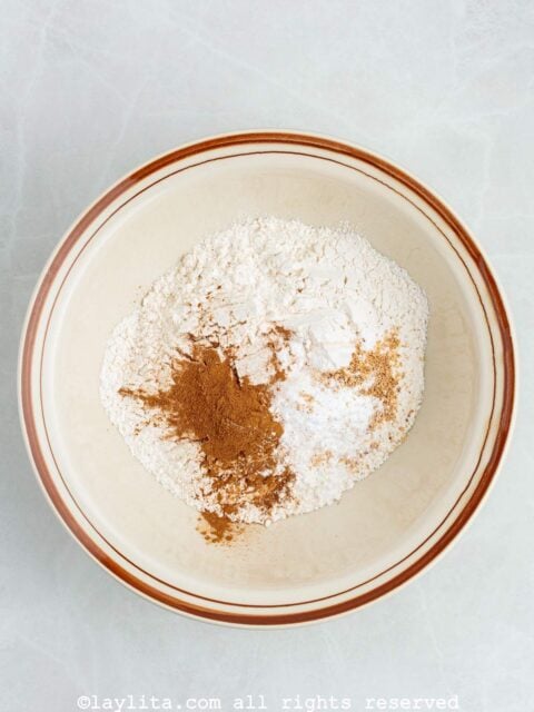 Overhead view of a mixing bowl with flour and spices
