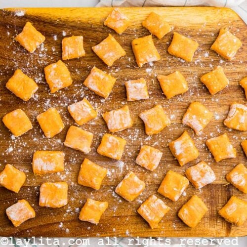 Overhead view of uncooked freshly made sweet potato gnocchi on a wood board