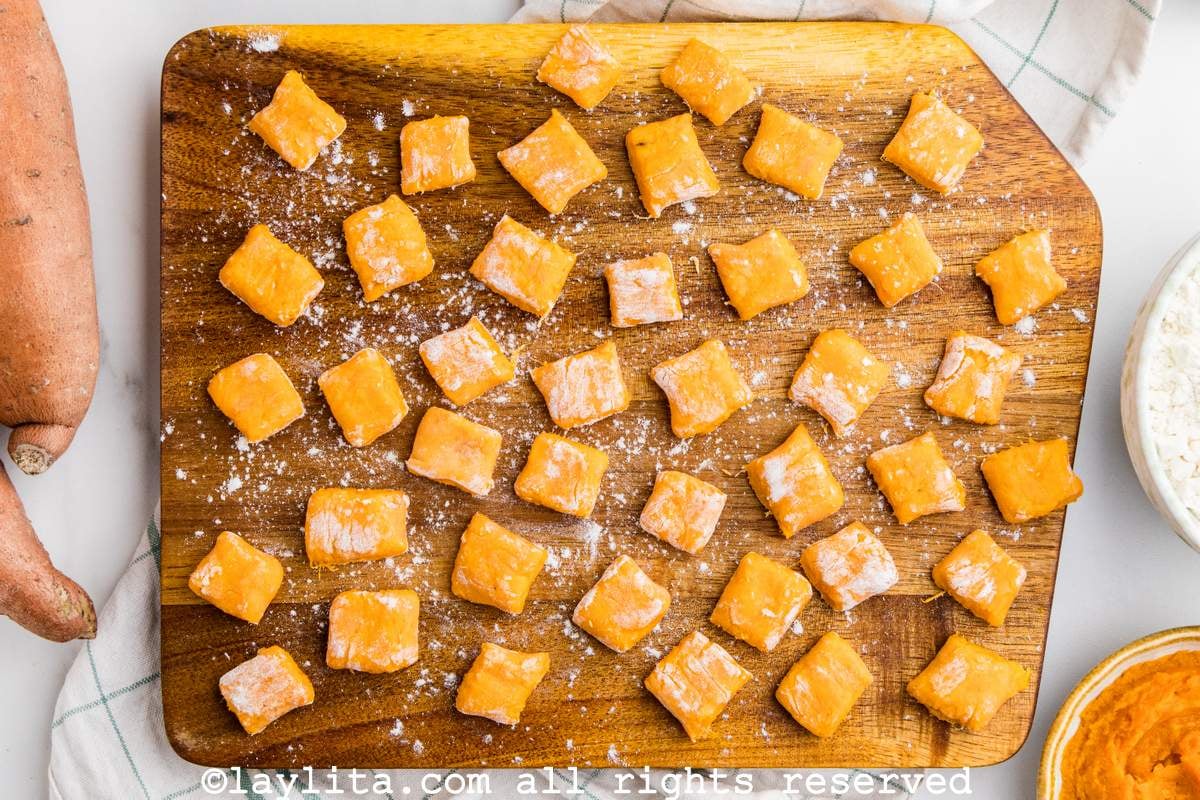 Overhead view of uncooked freshly made sweet potato gnocchi on a wood board