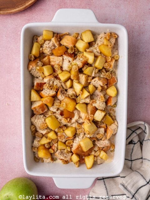 A white baking mold with unbaked apple bread pudding
