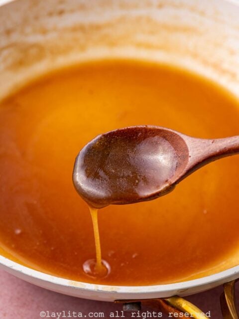 Salted caramel in a skillet with a spoon drizzling some it