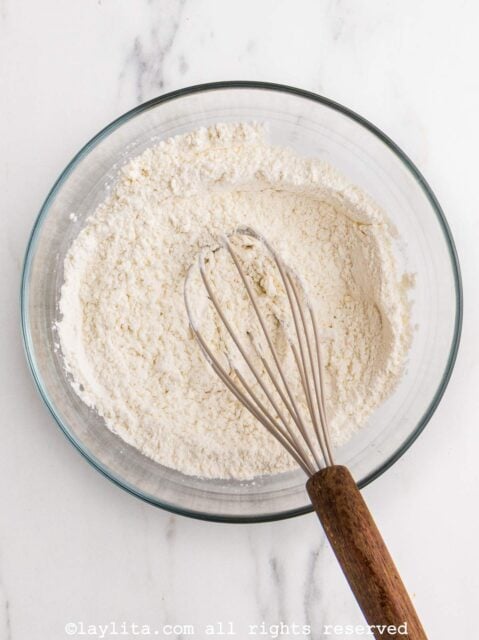 Flour and cornstarch being whisked in a glass bowl