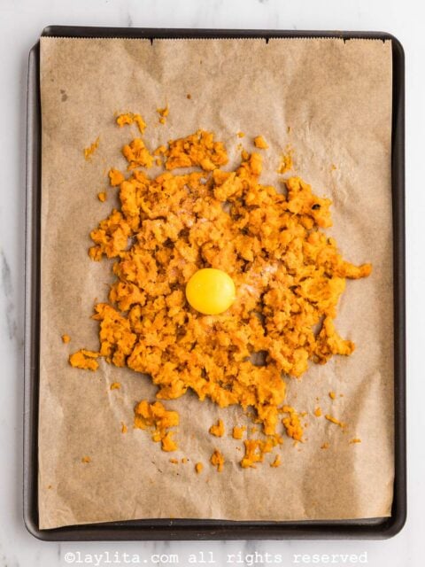Mashed sweet potato and an egg yolk on a baking sheet
