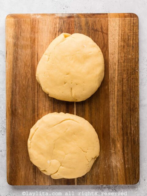 Two large discs of dough on a wood board