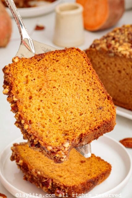 A spatula holding a slice of sweet potato bread
